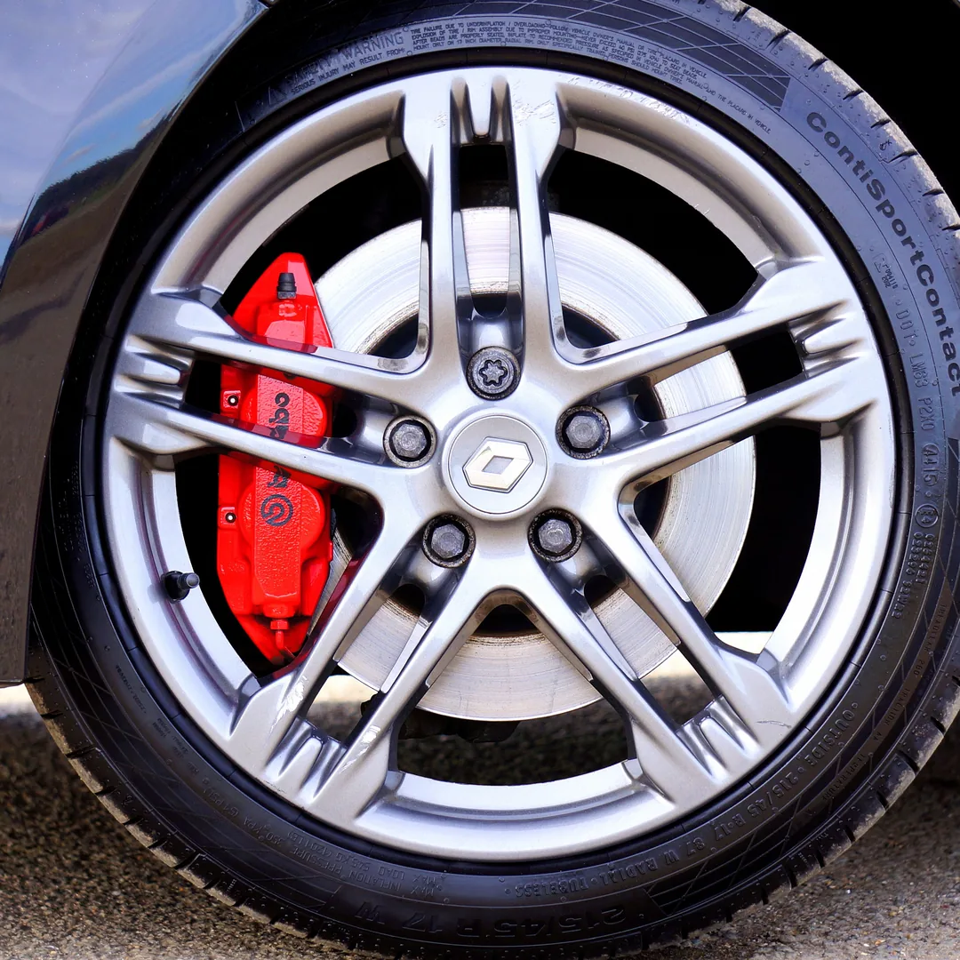 A stock photograph of a clean alloy wheel and red brake caliper, of the kind used in templated maintenance-tip posts.
